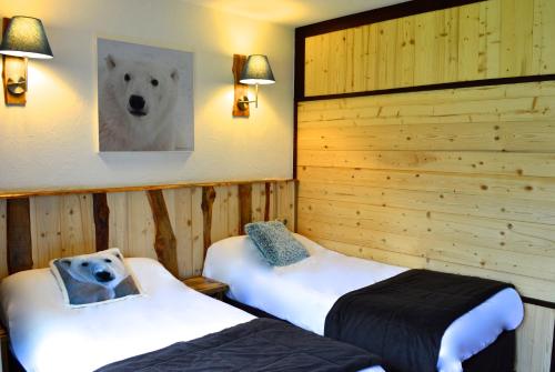 a room with two beds with a polar bear picture on the wall at Hôtel Serre Palas in Les Deux Alpes