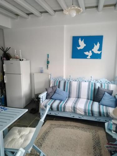 a living room with a couch and birds on the wall at Kamara in Kamarai