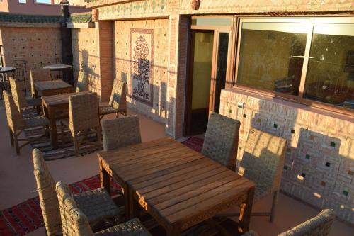 a wooden table and chairs on a patio at Kasbah Assafar in Kalaat MGouna
