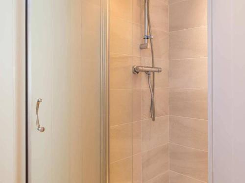 a shower stall with a glass door with a shower at Silverdale Lodge Hot Tub & Wifi in Warton