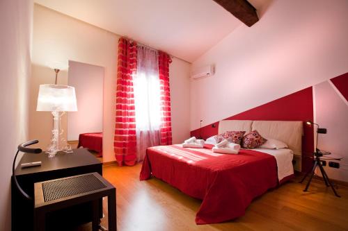 um quarto vermelho e branco com uma cama e uma janela em FILARMONICO SUITES em Verona