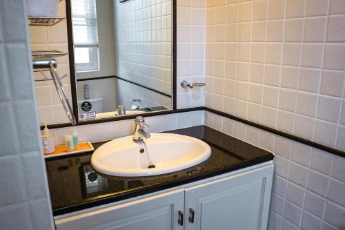 a bathroom with a sink and a mirror at Erinvale Garden cottage in Somerset West