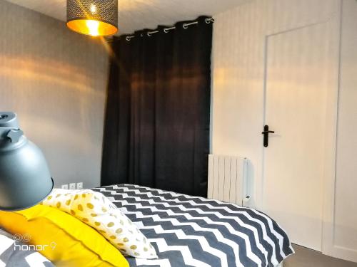 um quarto com uma cama com um edredão preto e branco em Appartement Le 146 Bis, avec Parking em Rennes