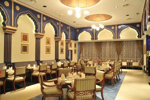 a restaurant with tables and chairs in a room at Mysore County Retreat in Mysore