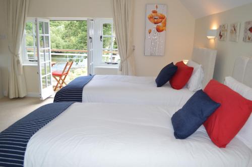 ビルス・ウェールズにあるPwll-y-Faedda Bed & Breakfastのベッドルーム1室(ベッド2台、赤と青の枕付)