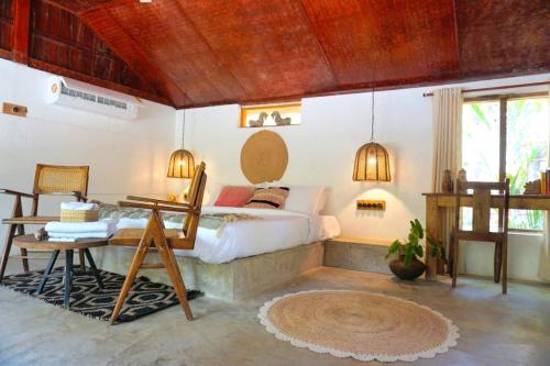 a bedroom with a bed and a table in a room at Sunsets and Palm Trees in Alleppey
