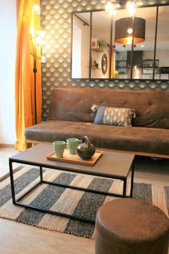 - un salon avec un canapé brun et une table basse dans l'établissement Superbe studio entre le port et le centre ville - LIT KING-SIZE, WiFi & NETFLIX gratuit, à Saint-Brieuc