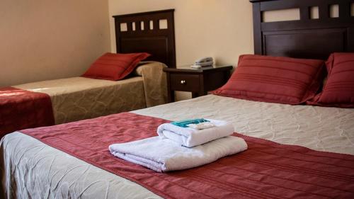 a hotel room with two beds with towels on them at Hotel Federico I in Concordia