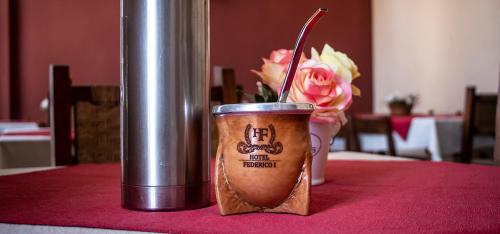 a cup of coffee sitting on a table with flowers at Hotel Federico I in Concordia