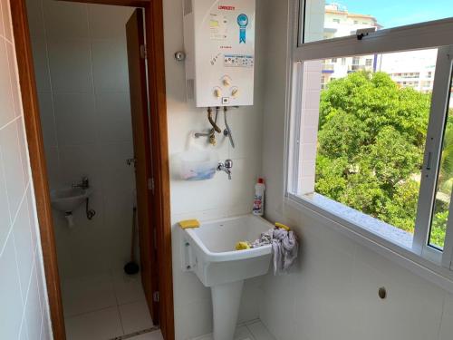 a bathroom with a sink and a window at Apto temporada Cabo Frio in Cabo Frio