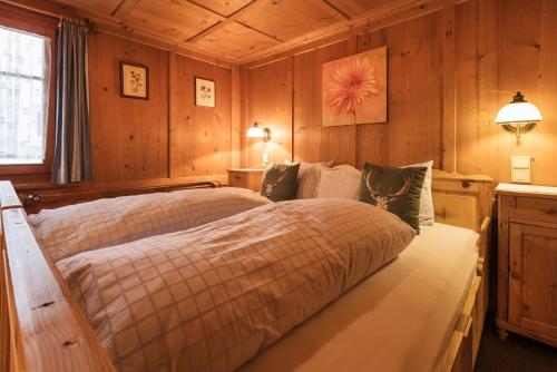 a bedroom with a bed in a room with wooden walls at Gasthaus Kreuz in Schruns-Tschagguns