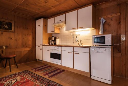 a kitchen with white cabinets and a microwave at Gasthaus Kreuz in Schruns-Tschagguns