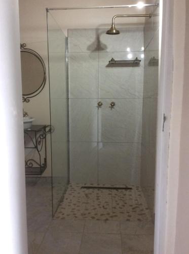 a shower with a glass door in a bathroom at Cozy Kosmos in Hartbeespoort