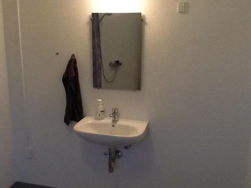 a white sink in a bathroom with a mirror at Feriehus Thy - I hjertet af Thy in Thisted