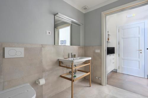 a bathroom with a sink and a toilet and a mirror at Apt. Fiordaliso - Pauline Suites, Palazzo Borghese in Florence