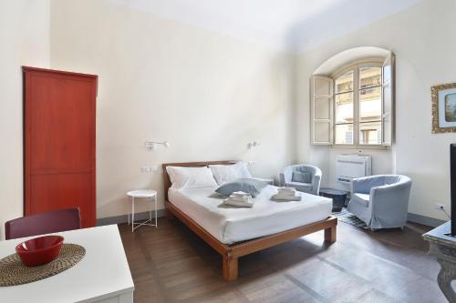 a bedroom with a bed and a table and chairs at Apt. Fiordaliso - Pauline Suites, Palazzo Borghese in Florence
