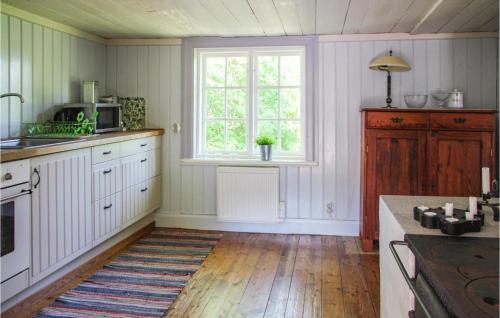 a kitchen with a sink and a window and a counter at Amazing Home In Gamleby in Gamleby