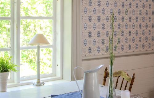une table avec une lampe et un vase sur une table dans l'établissement Gorgeous Home In Gamleby With House A Panoramic View, à Gamleby