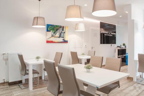 a dining room with white tables and chairs at B&B Fontana in Zagreb