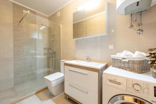 a bathroom with a toilet and a sink and a washing machine at Villa Tea in Cavtat