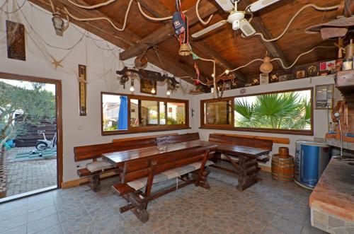 a dining room with wooden benches and windows at Luxury Apartments Silva with sea view in Trogir