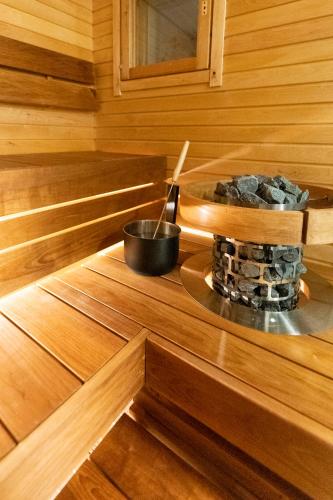 a stove in a wooden cabin with a pot on the floor at Ylläksen Yöpuu in Äkäslompolo