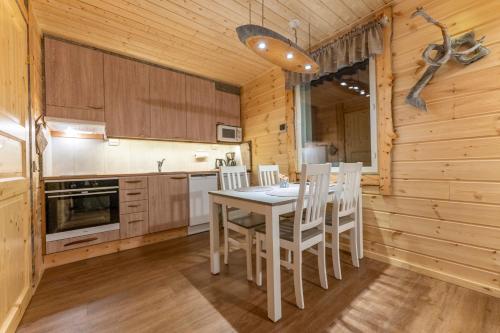 a kitchen with a table and chairs in a cabin at Ylläksen Yöpuu in Äkäslompolo