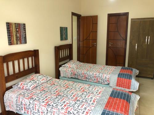 Duas camas sentadas uma ao lado da outra num quarto em Apartamento na Praia da Prainha - Arraial do Cabo. em Arraial do Cabo