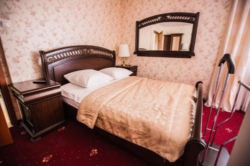 a bedroom with a bed with a mirror on the wall at Orion Hotel Parczew in Parczew