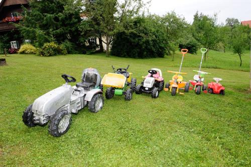 un groupe de tracteurs jouets garés dans l’herbe dans l'établissement Frühstückspension-Appartement Liebmann, à Schamberg