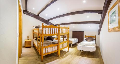 a bedroom with two bunk beds and a ceiling with beams at Hotel Les Neus in Pas de la Casa