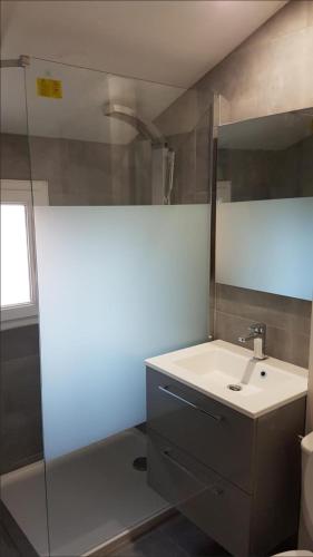 une salle de bain avec un lavabo et un miroir dans l'établissement Appartement T3 refait à neuf face à la mer, à Frontignan