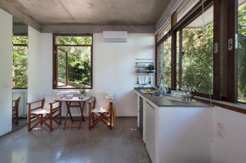 a kitchen with a table and chairs and windows at Studios Kyparissi & Spa in Tiros
