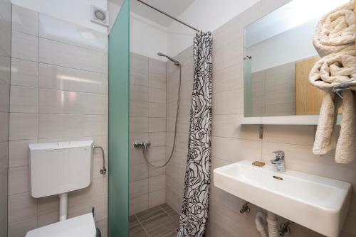 y baño con lavabo, aseo y ducha. en Villa Adriatic Rooms, en Mlini