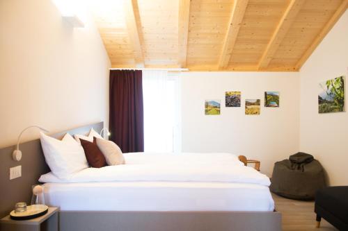 una camera da letto con un grande letto bianco e una finestra di 8 Grappoli Agritur a Trento