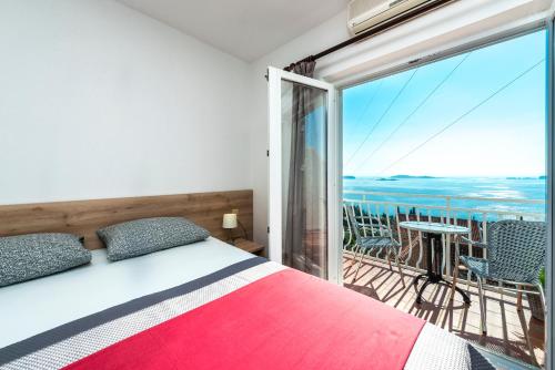 米利尼的住宿－Villa Adriatic Rooms，一间卧室设有一张床和一个美景阳台