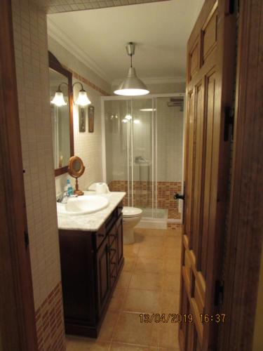 y baño con lavabo, aseo y espejo. en Casa Rural Antigua Ermita del Rosario en Teba