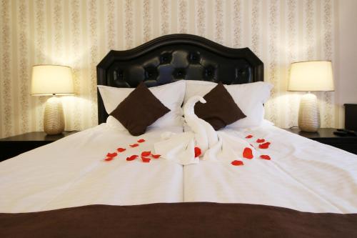 a bed with red roses on it with two lamps at Select House in Sibiu