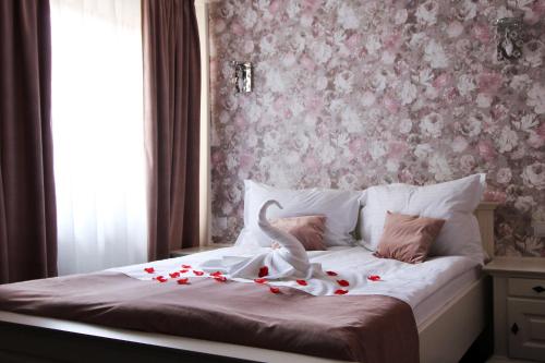 a bed with roses and a swan decoration on it at Select House in Sibiu