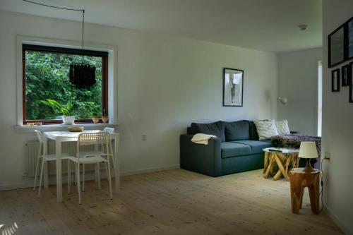 a living room with a blue couch and a table at Feriehus Thy - I hjertet af Thy in Thisted