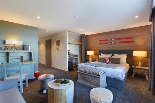 a bedroom with a bed and a living room with a table at La Mainaz Hôtel Restaurant Genève - Gex - Mijoux in Gex