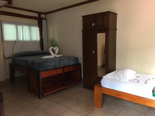 a bedroom with a bed and a dresser and a mirror at Tico Adventure Lodge in Sámara