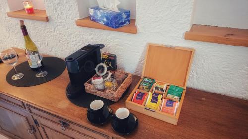 a counter with a coffee maker and a bottle of wine at Arber Apartments - Zwieslerwaldhaus in Lindberg