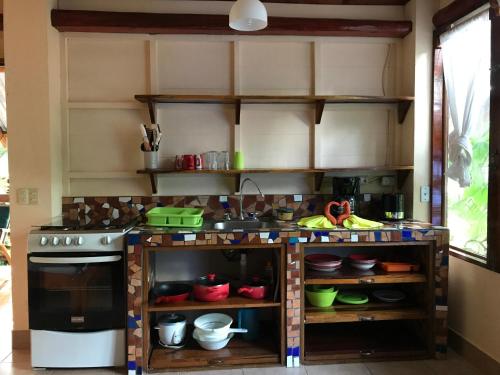 a kitchen with a stove and lots of dishes at Tico Adventure Lodge in Sámara