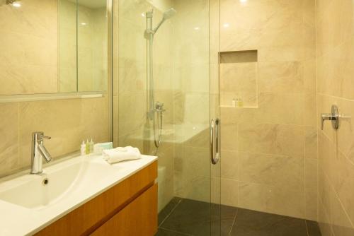 a bathroom with a shower and a sink and a tub at Villa Del Lago in Queenstown