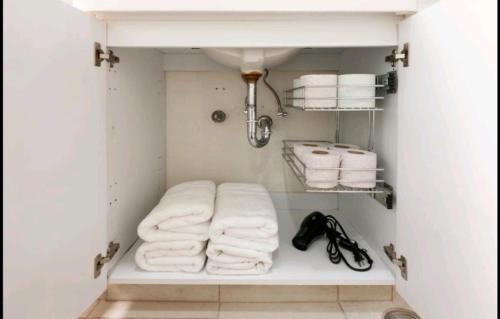 a small bathroom with white towels and a sink at Pennsylvania WTC High End 1parking/2BR/2BA in Mexico City