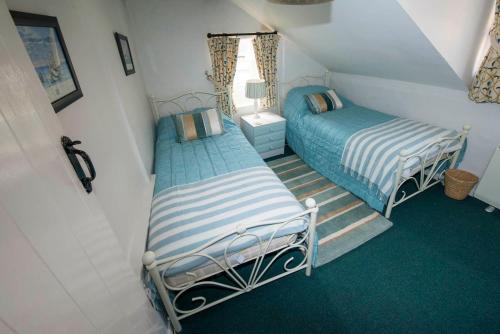 En eller flere senge i et værelse på Buttercup Cottage