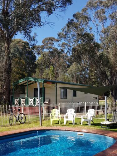 
a swimming pool with a lawn chair in front of it at Beechworth Holiday Park in Beechworth
