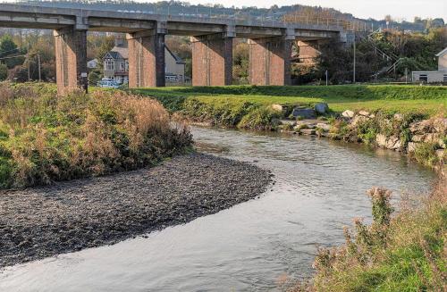 een rivier met een brug op de achtergrond bij Beach House, Llanddulas near Colwyn Bay in Llanddulas