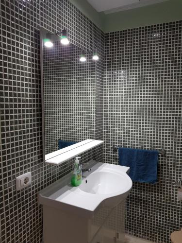a bathroom with a white sink and a mirror at alquilaencanarias Candelaria, Terrace and Pool ! in Candelaria